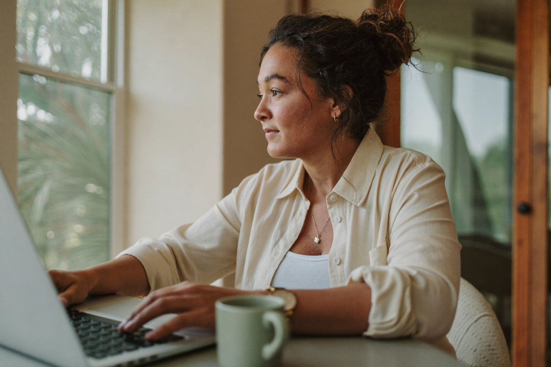 Mujer serena y enfocada trabajando en su laptop